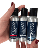 Hands holding three 2.7 oz silver bottles of OBSESS hand sanitizer.