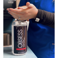 Nurse wearing blue uniform with black sleeves using the OBSESS peppermint 32 oz hand sanitizer.